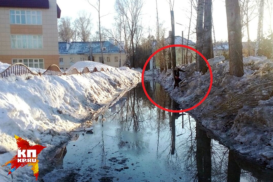 На снимке видно, как мужчина ведет ребенка по грязному снегу вдоль лужи. Фото: Алексей ГУРСКИЙ, слушатель Радио «Комсомольская правда»