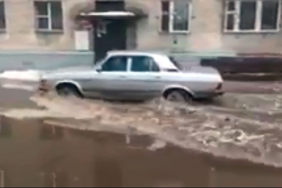Фото: кадр видео. Вода в луже скрывала колесо легковушки на треть.