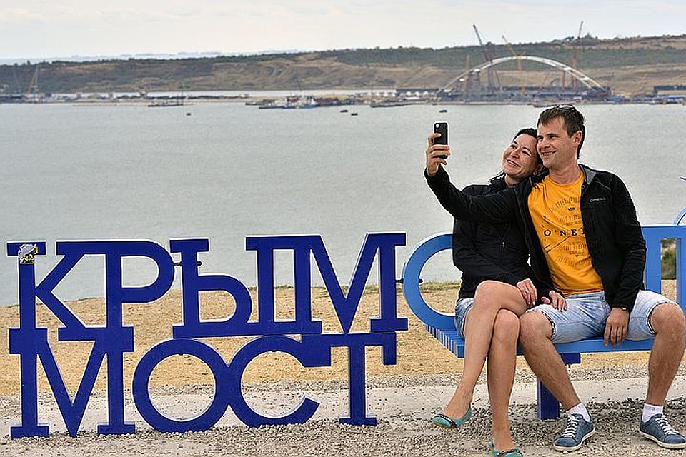 Люди фотографируются на фоне Керченского пролива, через который был построен Крымский мост. ФОТО Лев Федосеев ТАСС