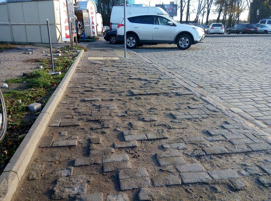 Тактильная плитка виднеется в конце этого тротуара