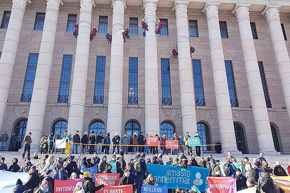 Восемь демонстрантов залезли на колонны здания финского парламента. Фото: Anne Orjala / Yle