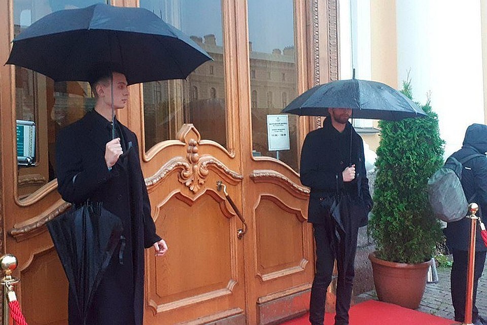 Перед Юсуповским дворцом гостей встречают крепкие мужчины с черными зонтами. Они прикрывают участников торжества - и от дождя, и от фотографов