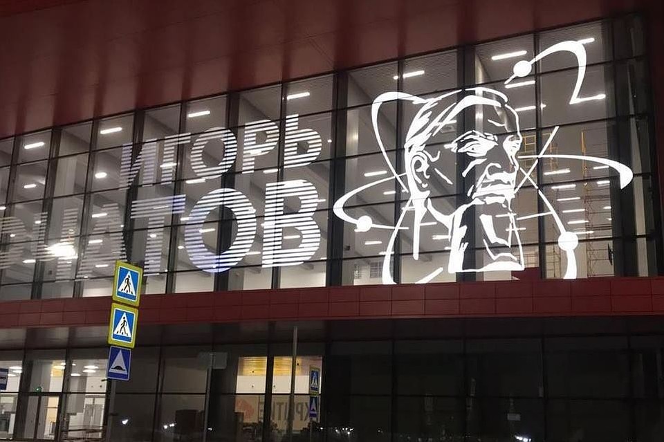 В темноте на фасаде нового терминала сияет электрическими огнями имя физика Игоря Курчатова. Фото: соцсети.