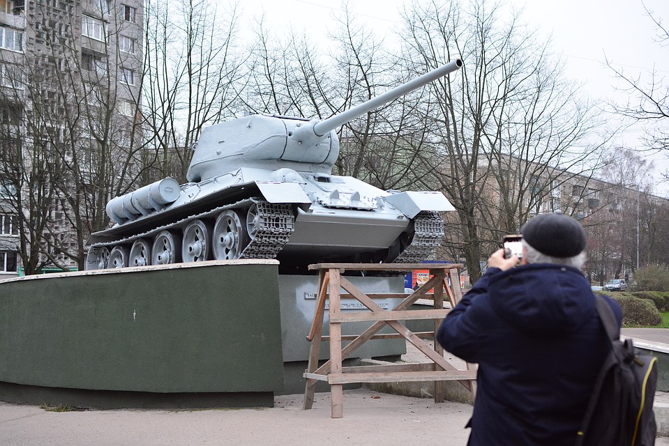Танк стал белым. Прохожие не упускают возможность сделать фотографию на память.