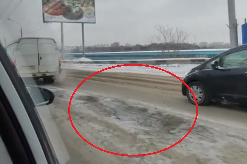 Опасную яму на Октябрьском мосту оцепили полицейские. Фото: стоп-кадр