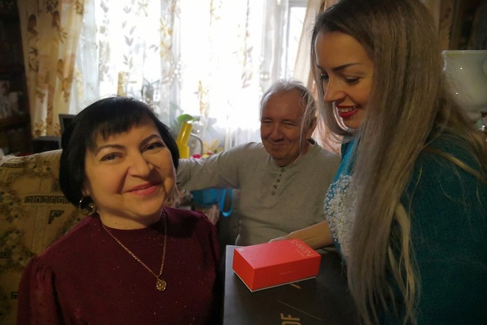 Евгения Мартынова вручает ноутбук и телефон имениннице.