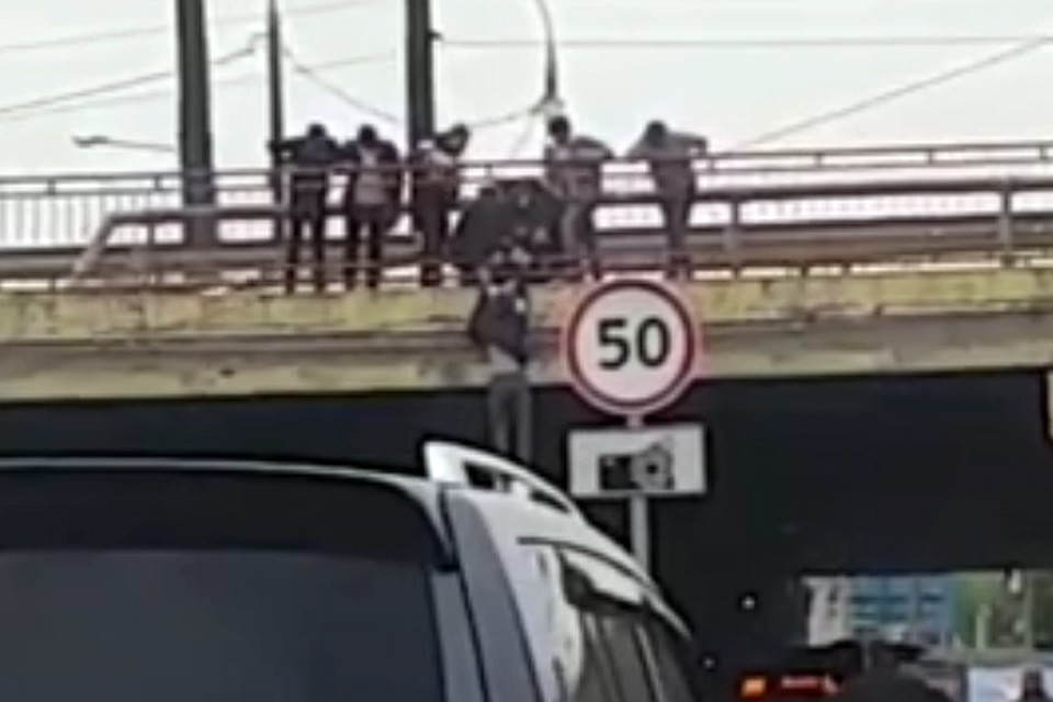 Под ногами бедняги - автомобильная дорога, так что упади он вниз, не известно, чем бы все закончилось