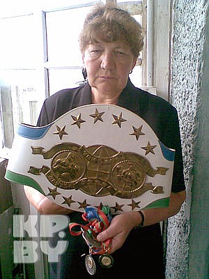Мама Виталия Шкрабы с чемпионским поясом и медалями сына.