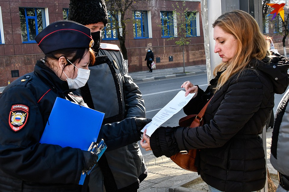 Женщина предъявляет справку с предприятия о том, что имеет работать в офисе. Фото: Кирилл ВЕРШИНИН