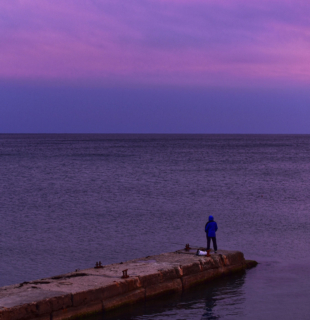 рыбак ловит рыбу на закате