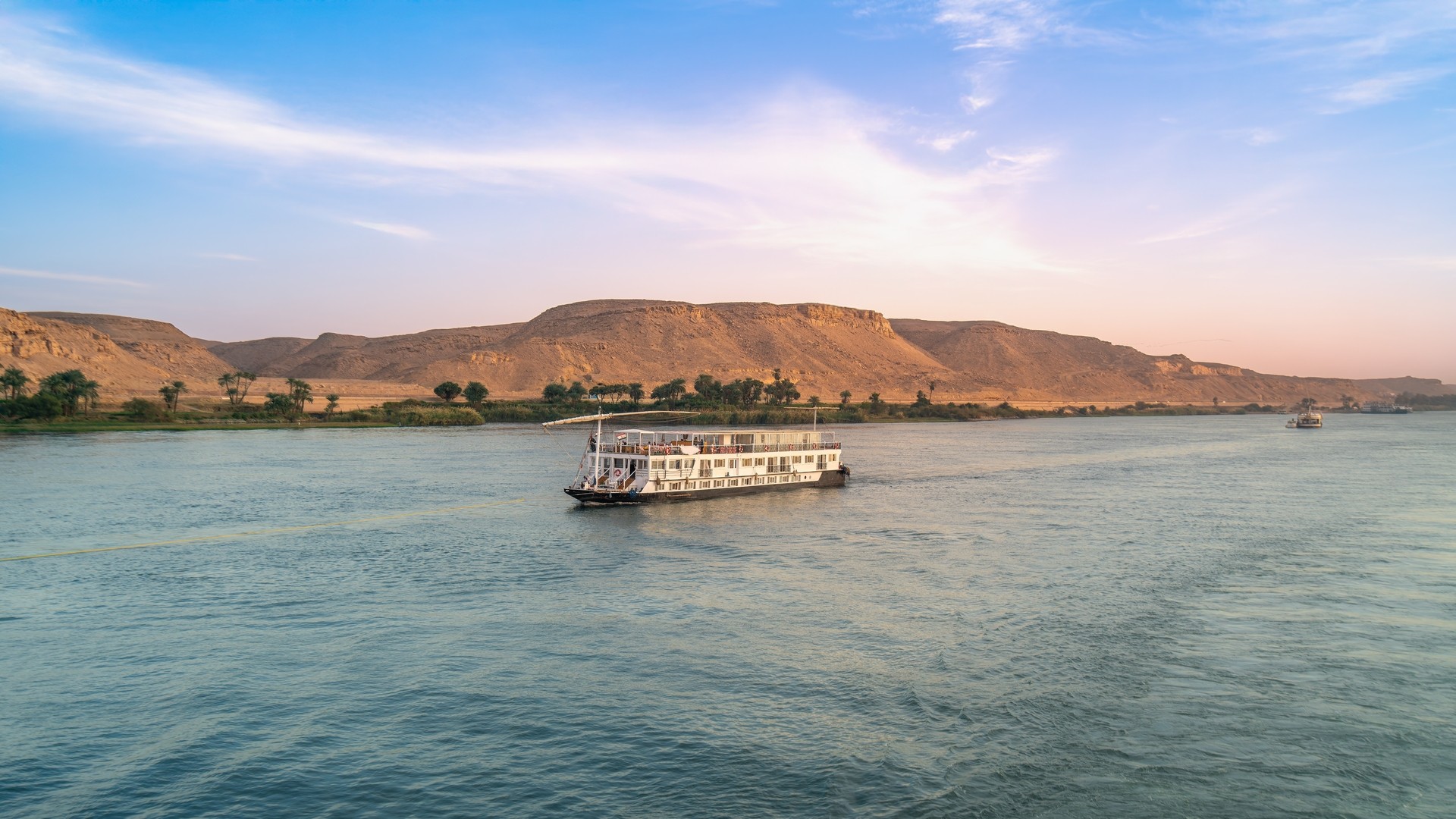 Круизный катер плывет по Нилу в городе Асуан.