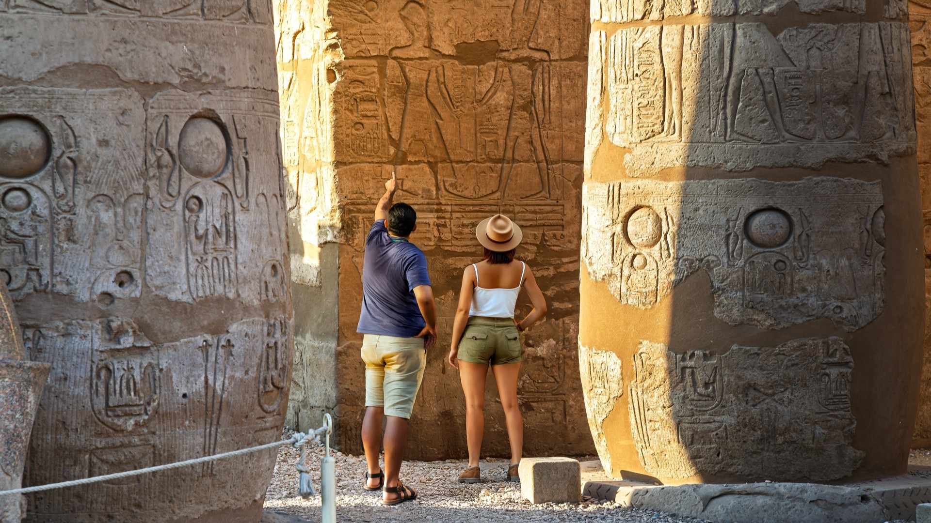 Туристы в Луксоре разглядывают древние рисунки.
