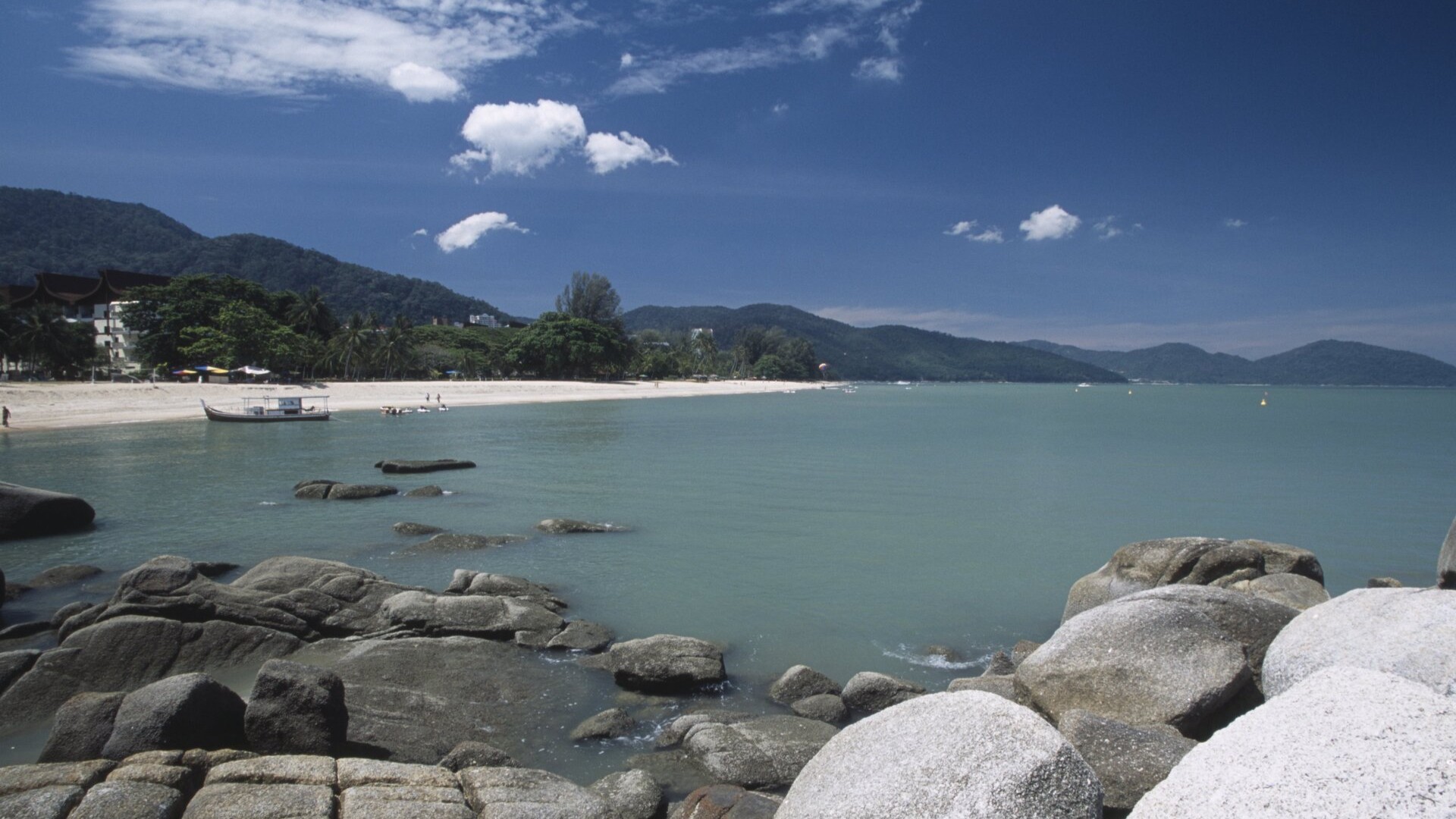 Вид на скалы и бирюзовую бухту на курорте Бату-Ферринги, остров Пинанг.